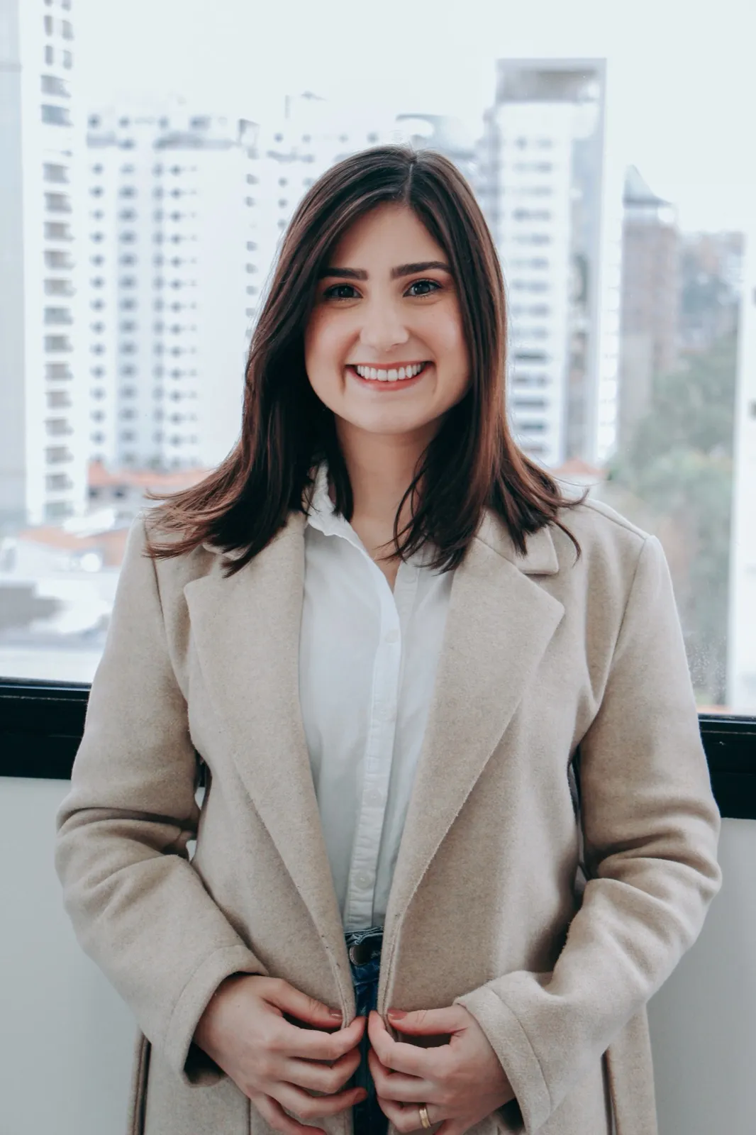 Bruna Rocha em pé, com a paisagem urbana de São Paulo ao fundo